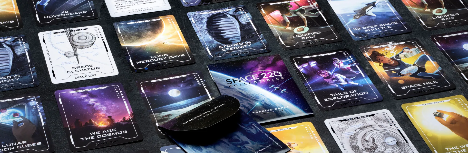 Space 220 trading cards laying on a table with a deck laying across.