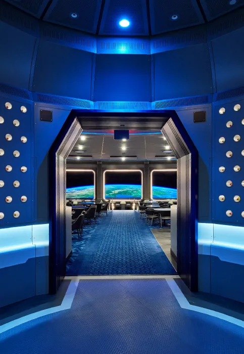 A blue hallway with a spaceship in the background.